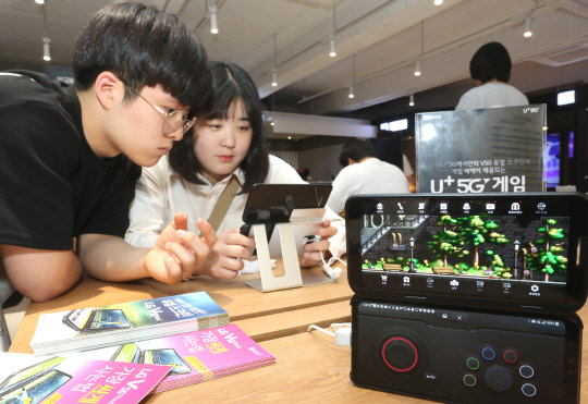 LG유플러스 5G 체험관을 방문한 고객이 V50 ThinQ(씽큐)듀얼스크린을 활용한 콘텐츠를 감상하고 있다.  LG유플러스 제공